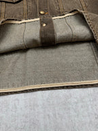 Dark gray denim jacket sleeve cuff with interior panel and topstitched edge