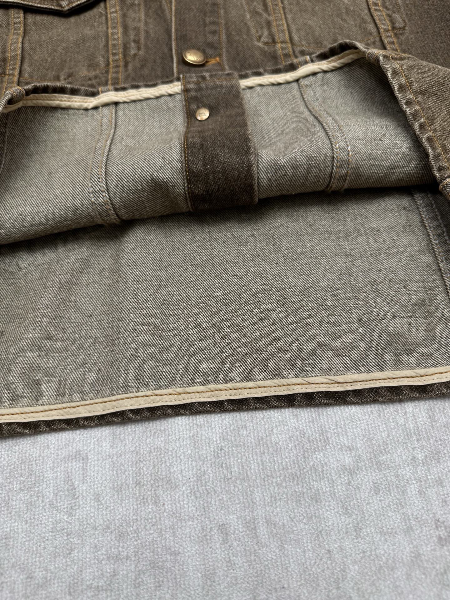 Dark gray denim jacket sleeve cuff with interior panel and topstitched edge