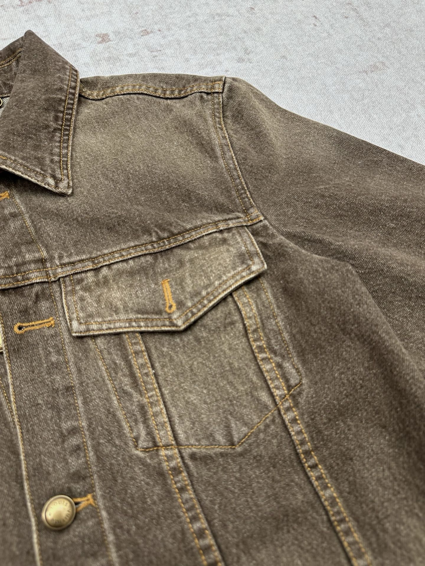 Dark gray denim jacket chest yoke and snap flap pocket detail