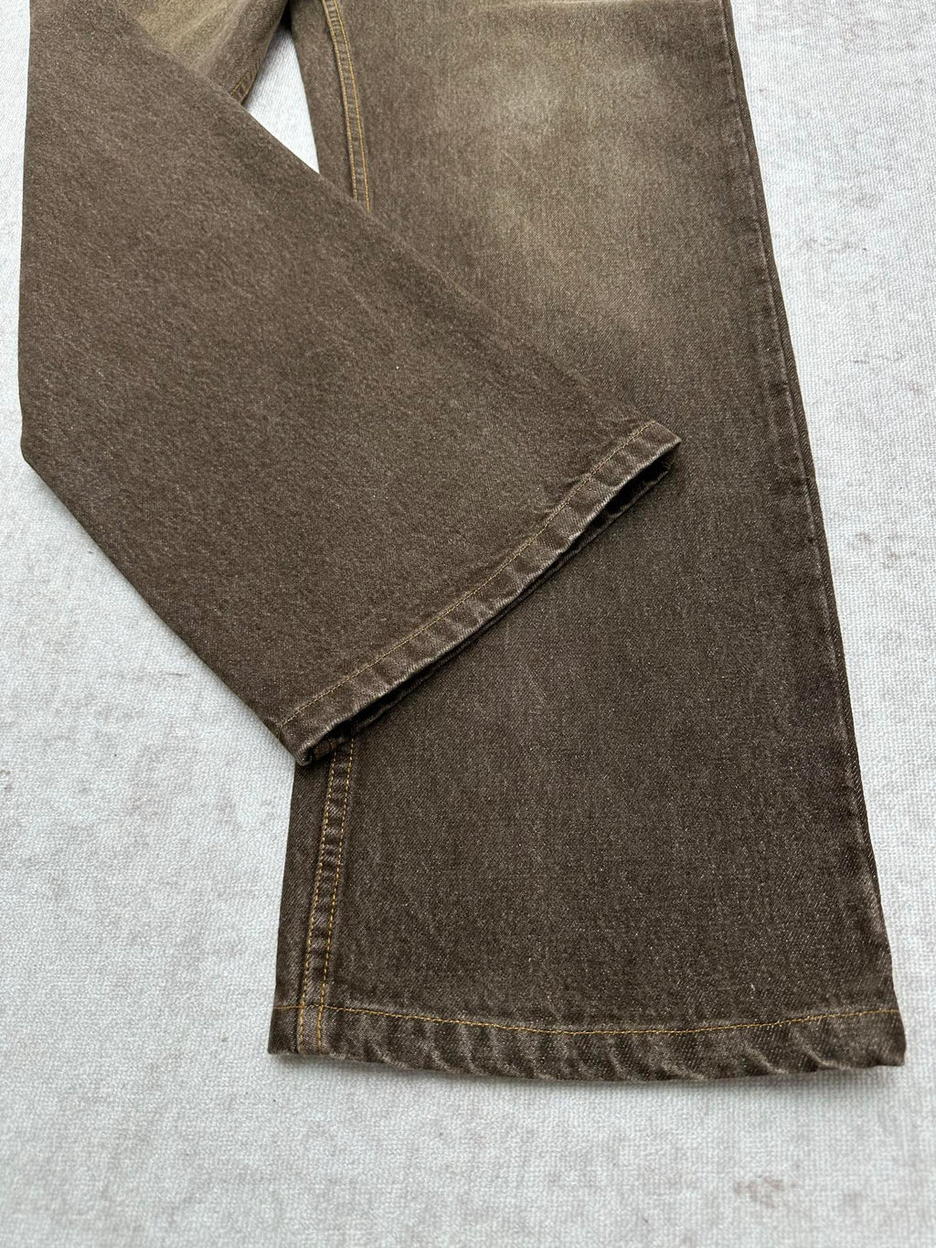 Brown denim jeans folded detail with stitched hem and side seam