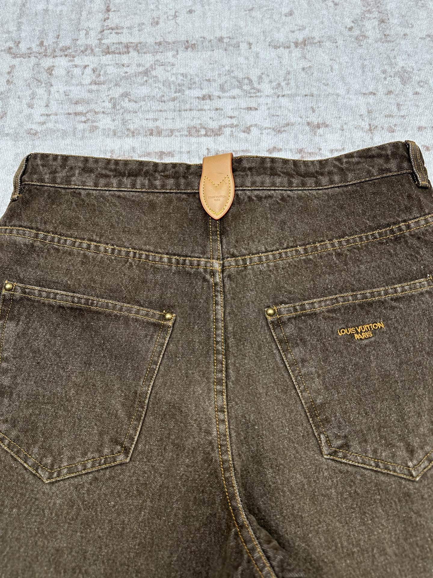 Brown denim jeans back view with leather patch and two front/side patch pockets