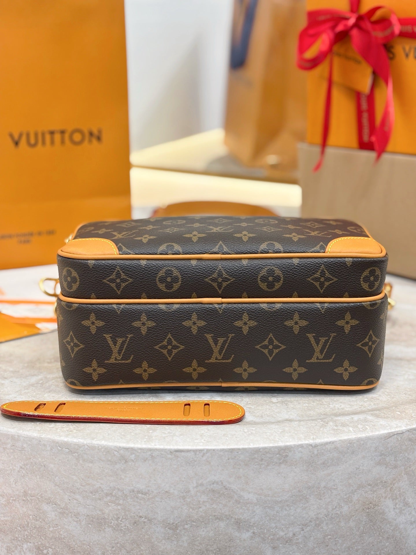 Louis Vuitton monogram crossbody bag with tan trim and gold zipper, top view