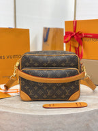 Louis Vuitton crossbody bag with monogram canvas, tan trim, and gold chain straps