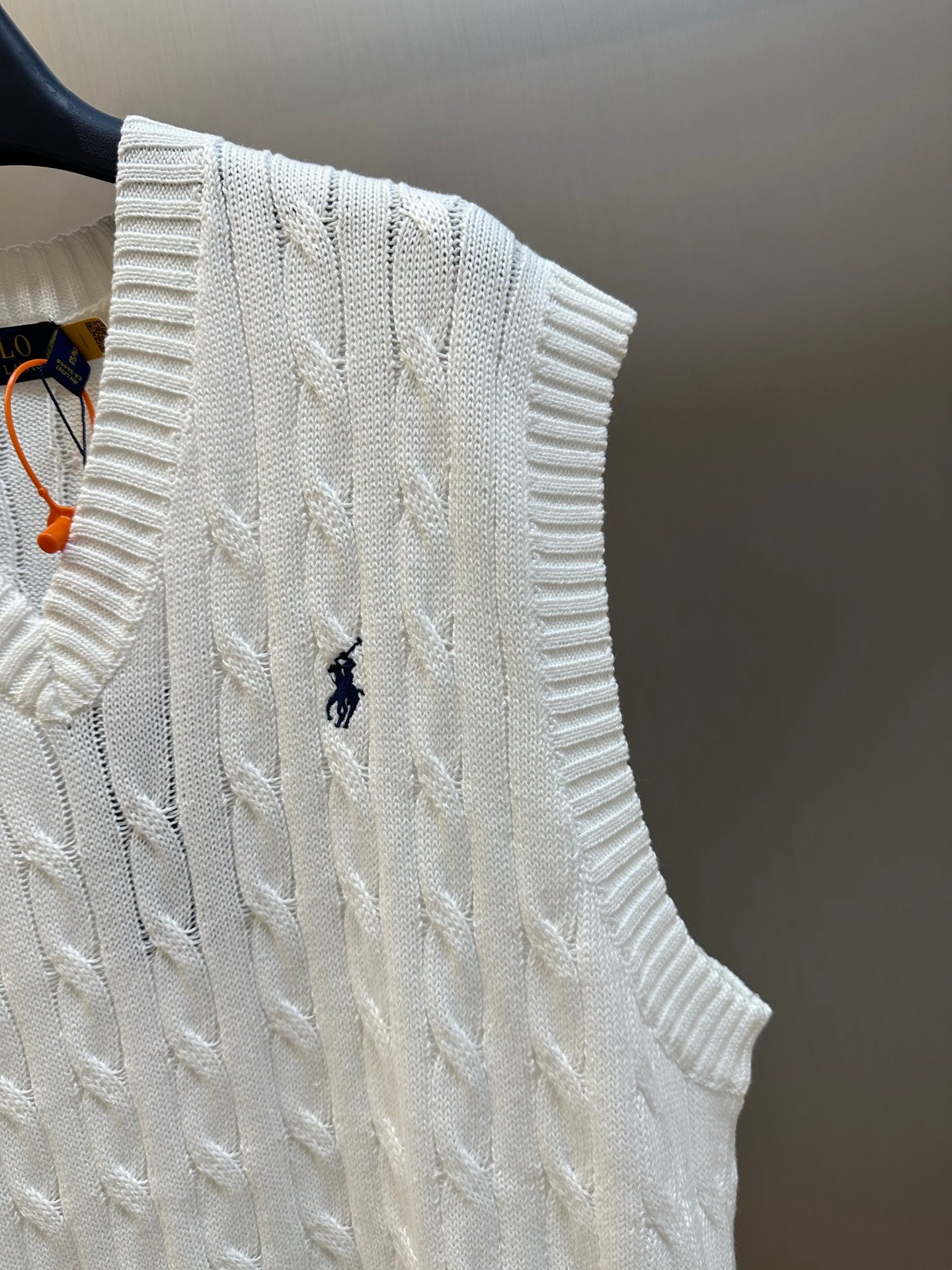 White cable-knit sweater vest with embroidered polo logo on the front