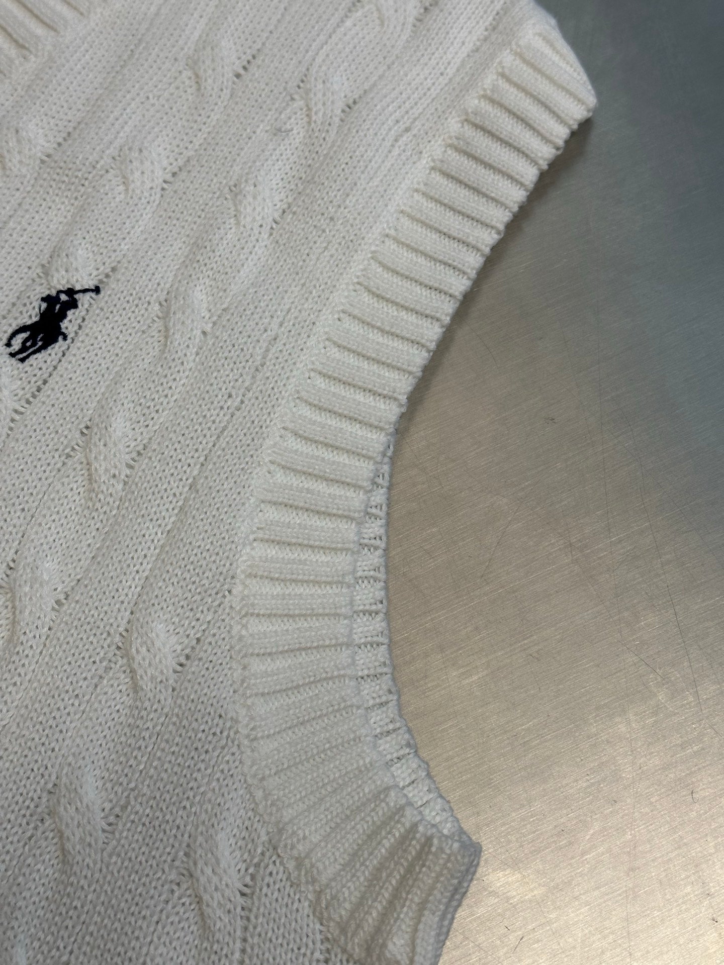 White cable-knit sleeveless sweater with embroidered Polo pony logo