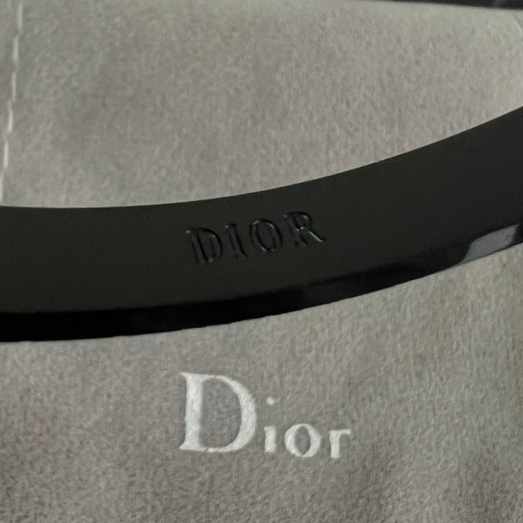 Black cuff bracelet with Dior logo embossed on the inner band