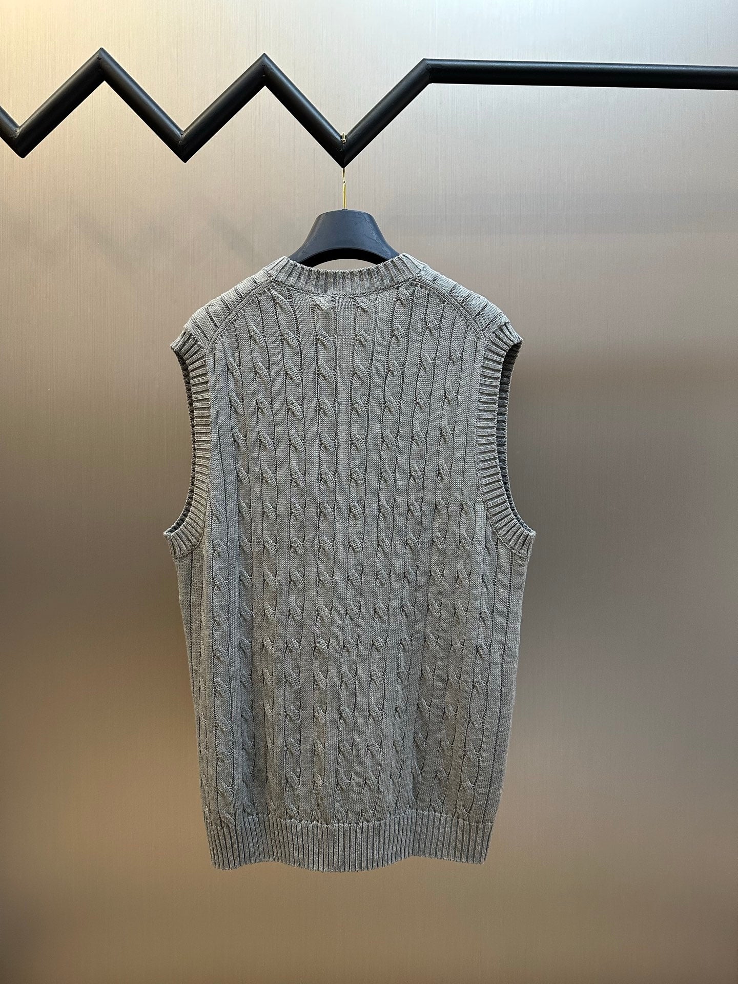 Gray cable-knit sweater vest with ribbed hem and V-neckline