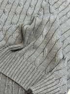 Gray cable-knit sleeveless sweater vest folded, showing cable knit texture