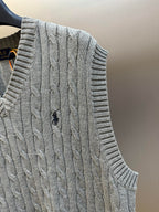 Gray cable-knit sweater vest with ribbed armhole and textured cable pattern