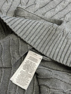 Gray cable-knit sweater vest hem with ribbed edge and care label