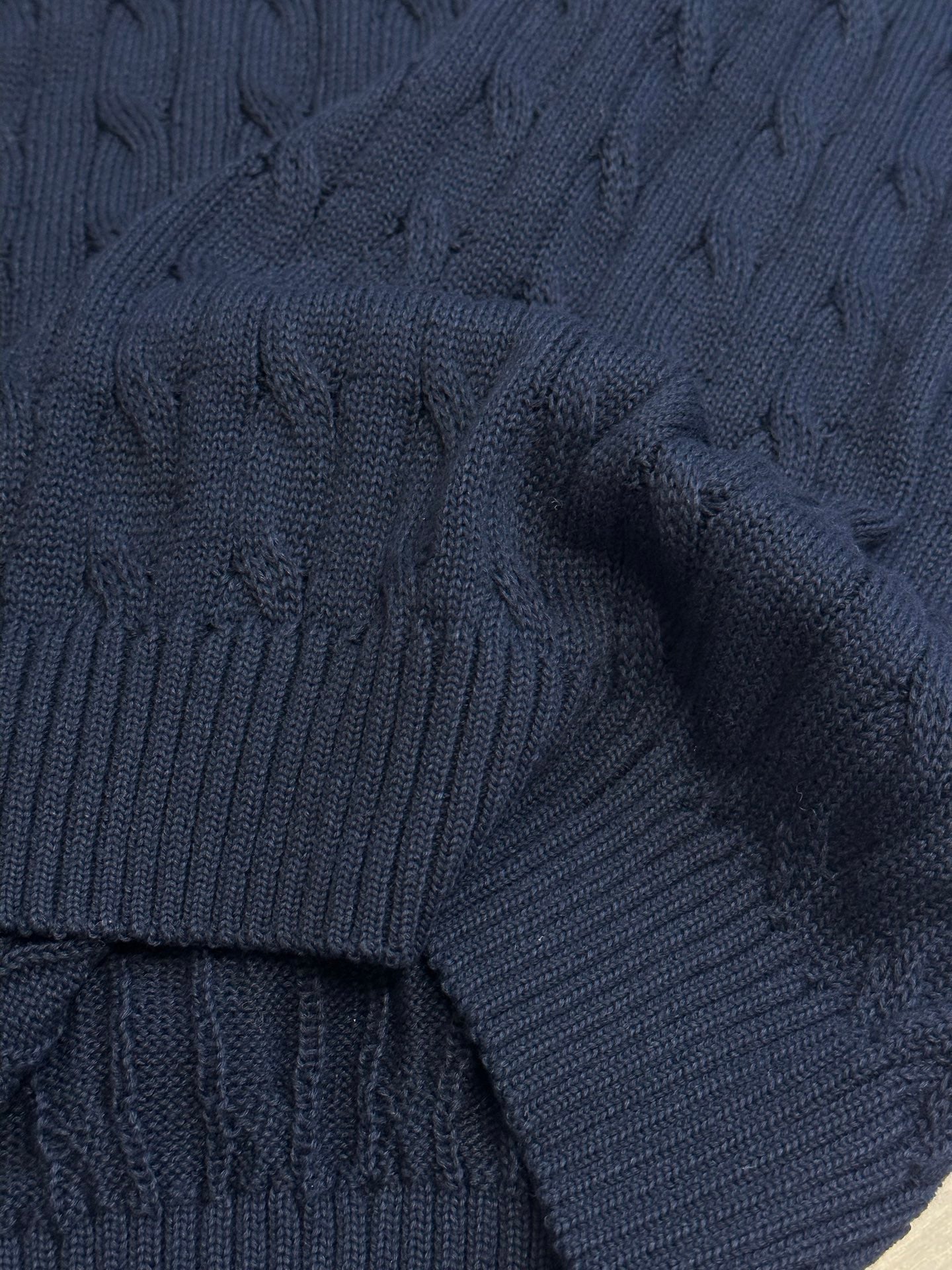 Navy ribbed knit sweater vest sleeve cuff with textured cable pattern