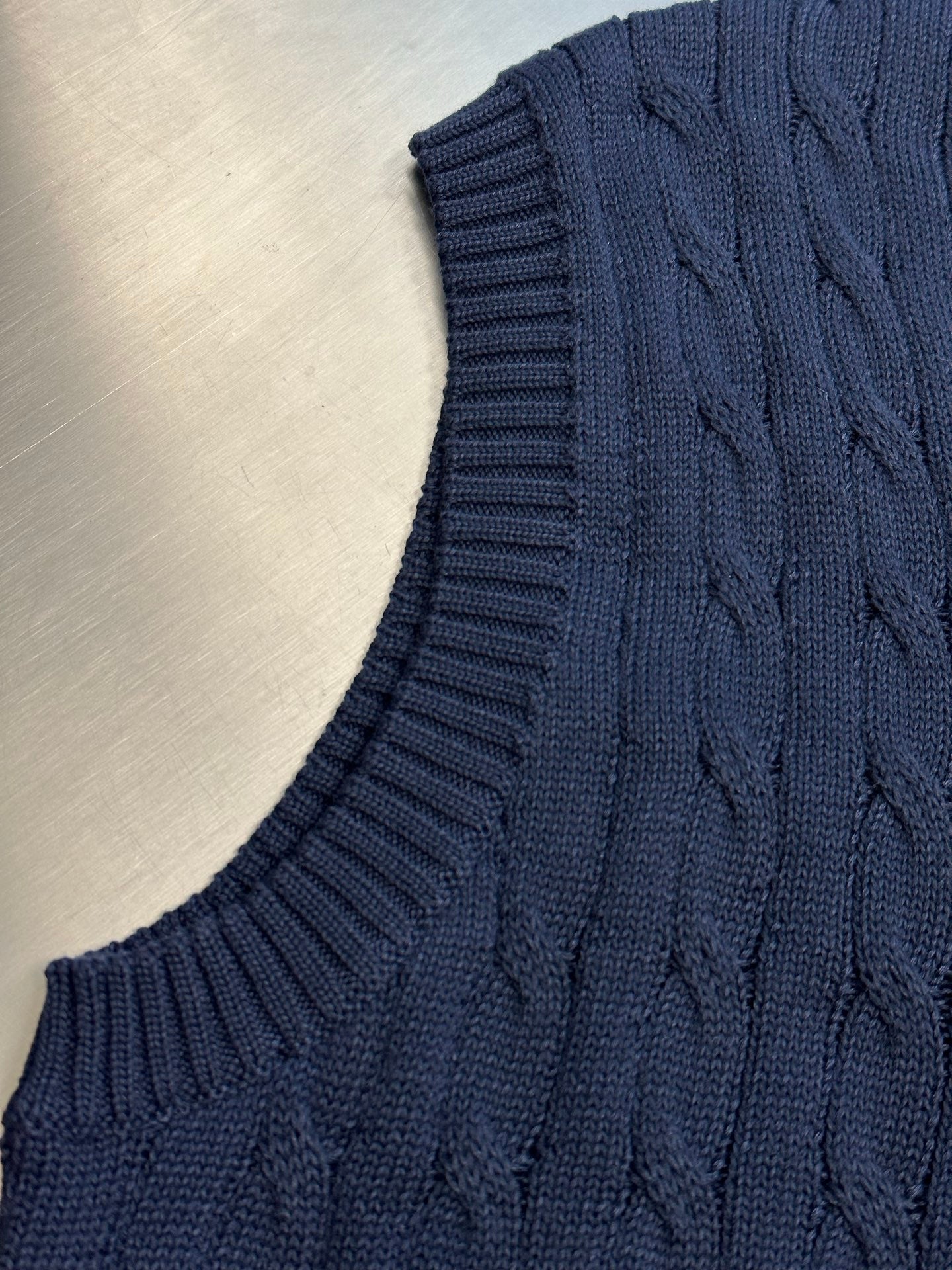 Navy sleeveless sweater vest with ribbed knit hem and cable texture