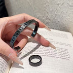 Black engraved cuff bracelet and matching ring with Dior logo details