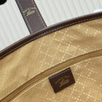Inside tote bag view with beige lining, brown leather trim, and gold zipper pull.