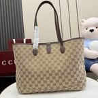 Beige GG monogram tote bag with dark brown leather handles and gold central clasp.