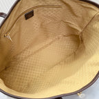 Tote bag interior lining in beige with brown leather trim around the opening.