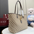 Beige GG monogram tote bag with dark brown leather straps and gold lock hardware.