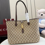 Tote bag with beige GG monogram canvas, dark brown leather handles, and gold clasp hardware.