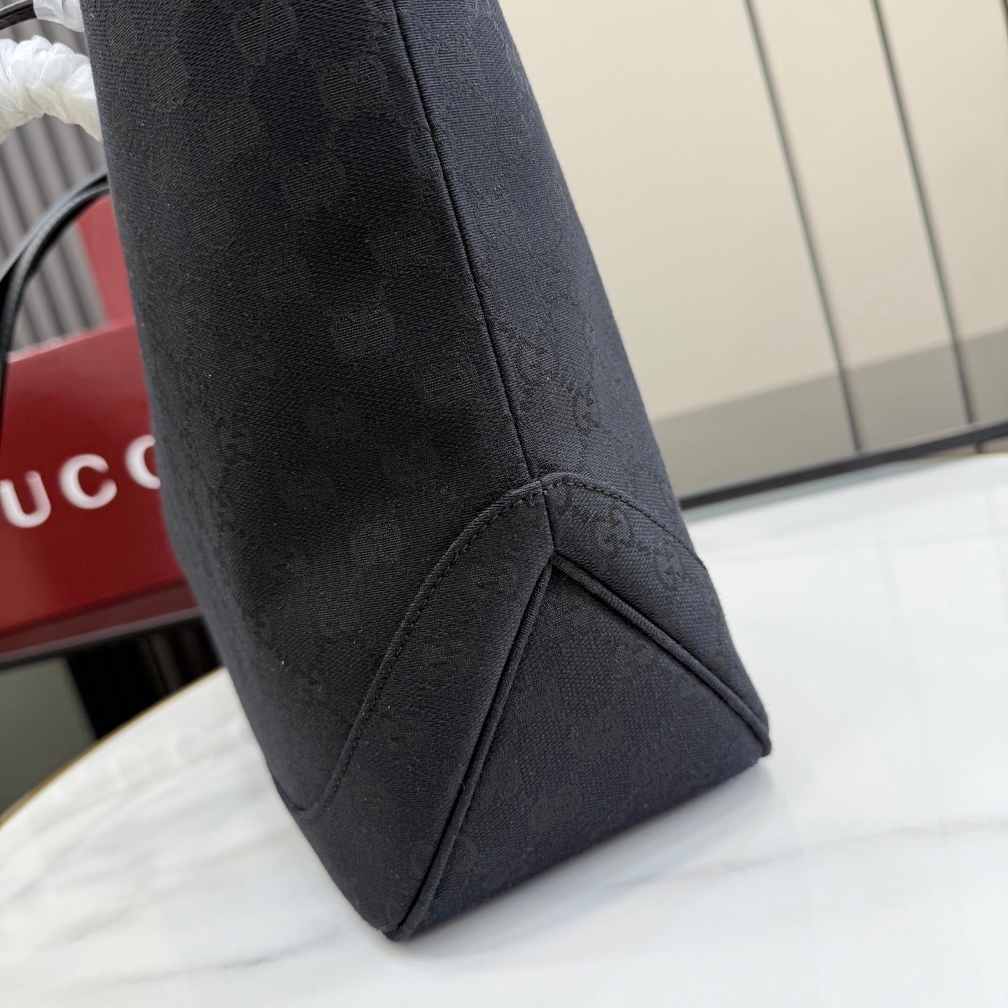 Gucci tote bag bottom corner in dark GG monogram canvas with leather edge trim
