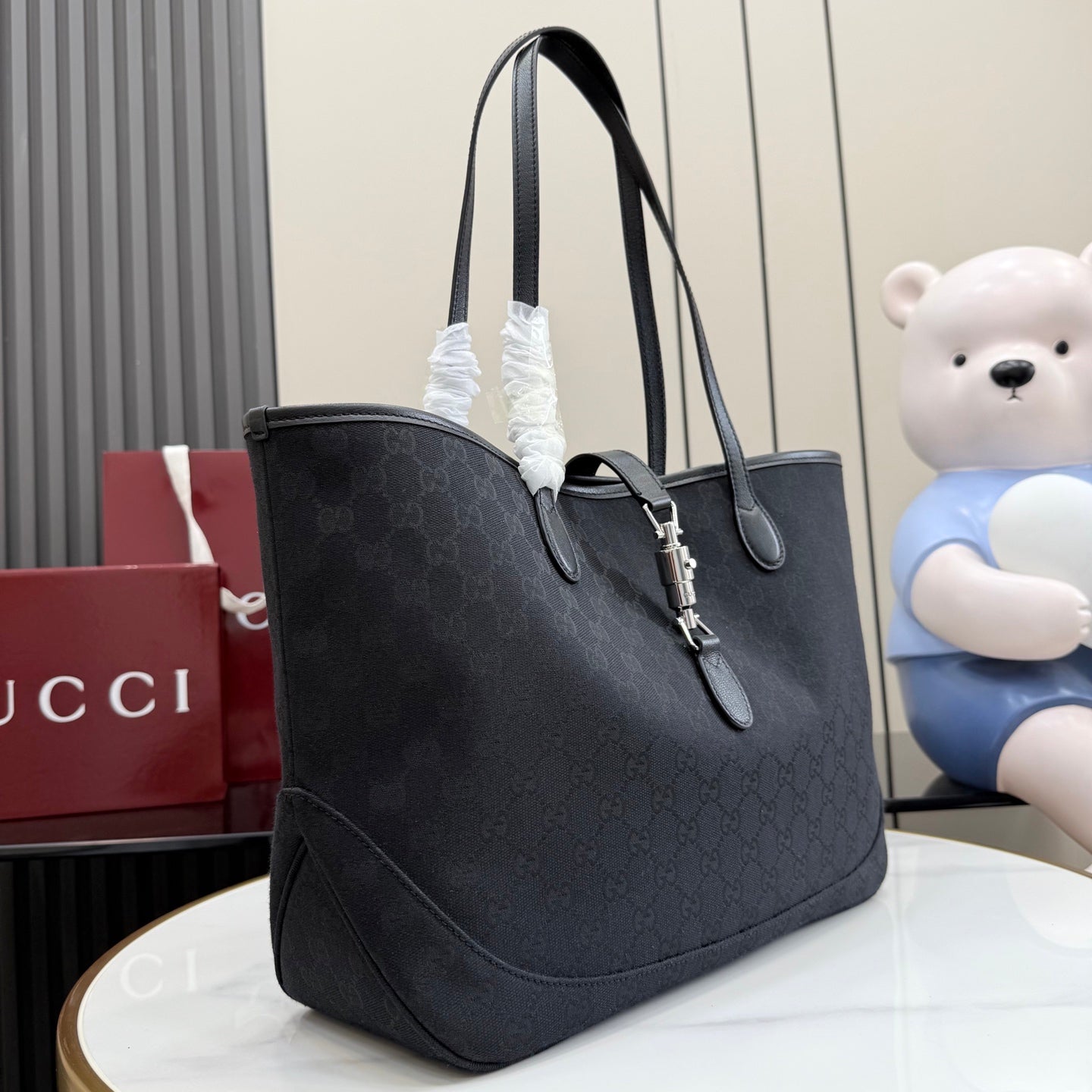 Gucci tote bag in dark GG monogram canvas with leather handles and hanging key charm