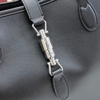 Gucci black leather tote bag close-up of front clasp and metal hardware