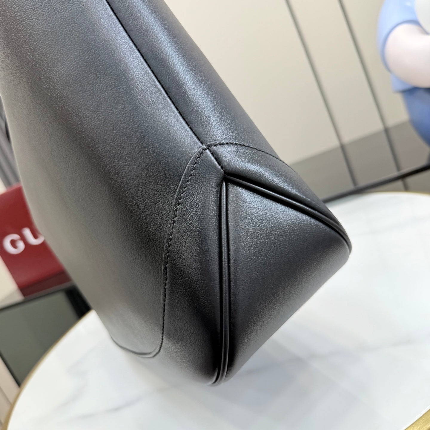 Gucci black leather tote bag corner seam and curved side panel stitching