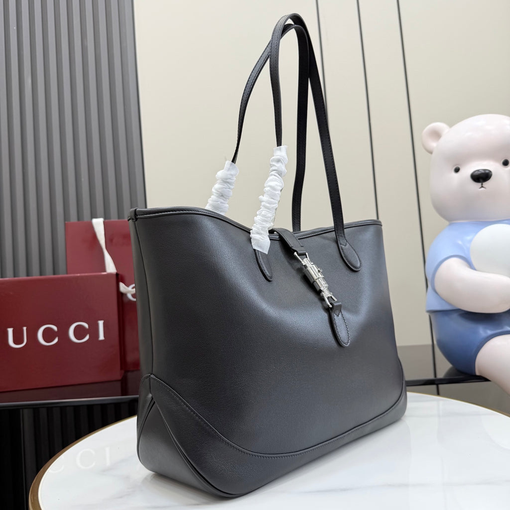 Gucci black leather tote bag with shoulder handles and engraved clasp detail