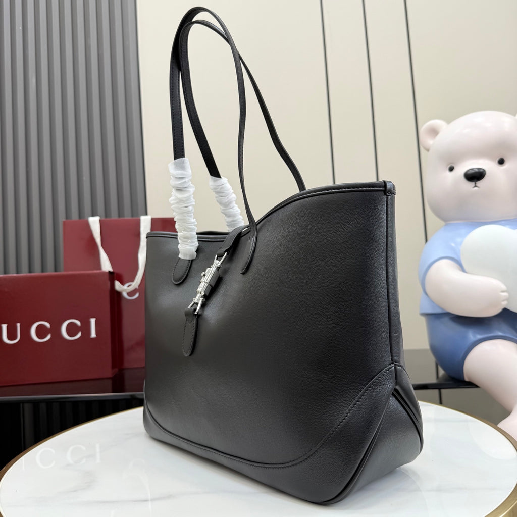 Gucci black leather tote bag side view with top handles and clasp hardware