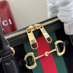 Gucci bag zipper pull detail with gold hardware and green-red-green web stripe