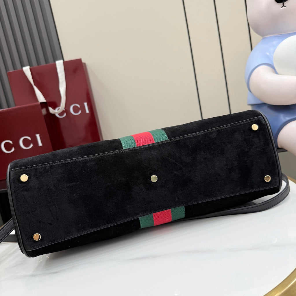 Gucci bag with wide black flap, green-red-green stripe, and gold studs