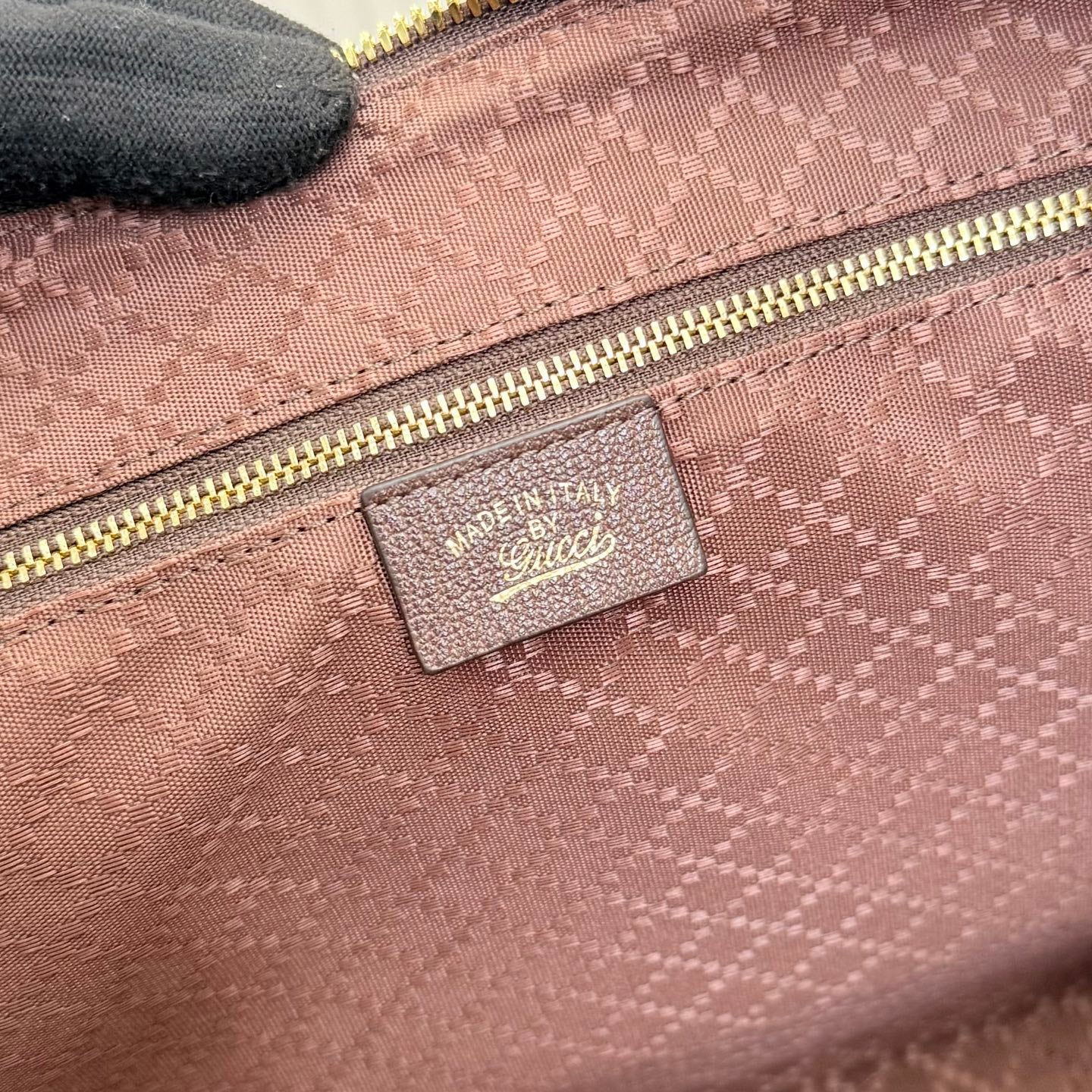 Gucci handbag interior pocket with textured light pink fabric and logo label