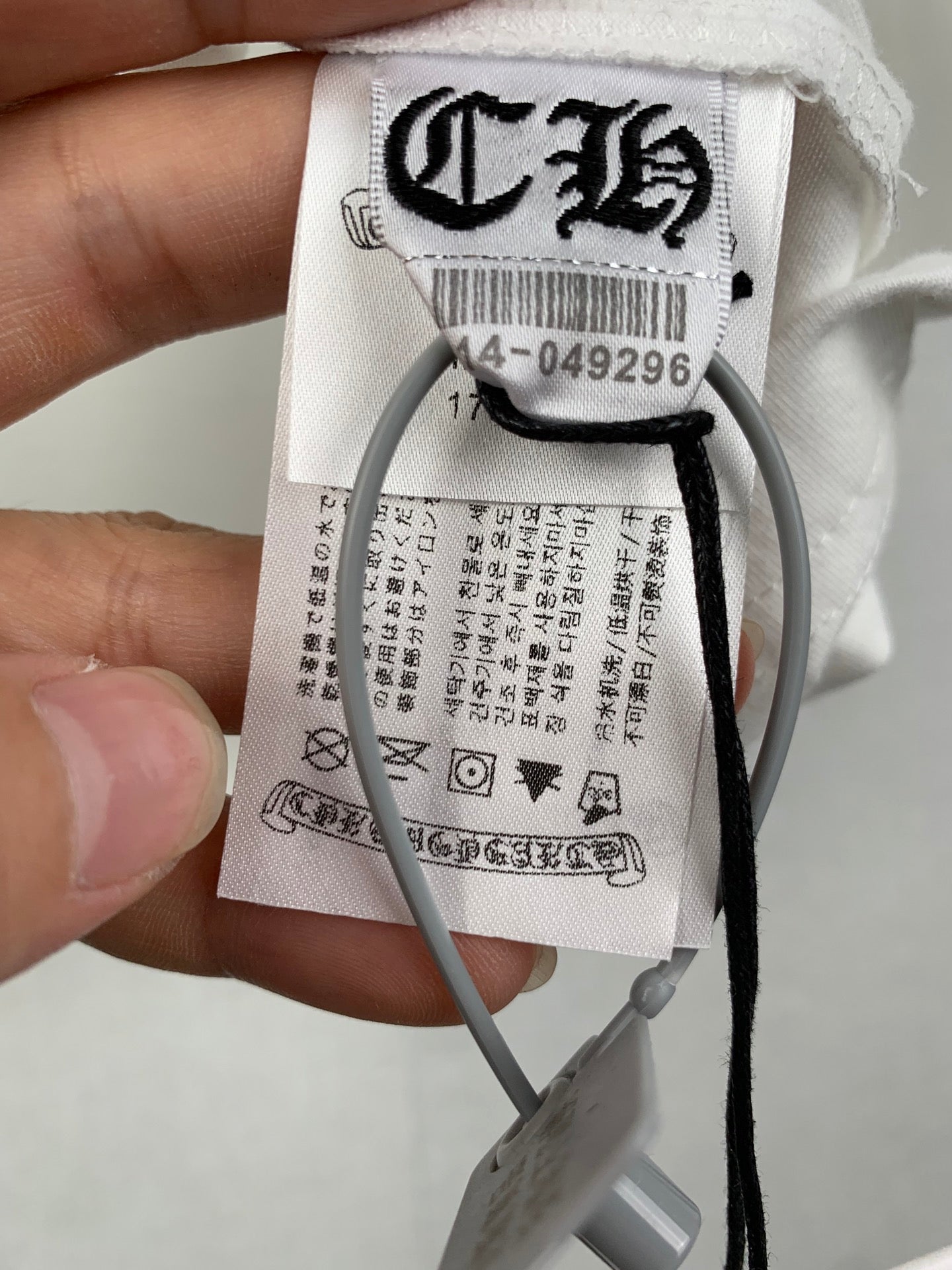 White T-shirt care label with barcode and product details