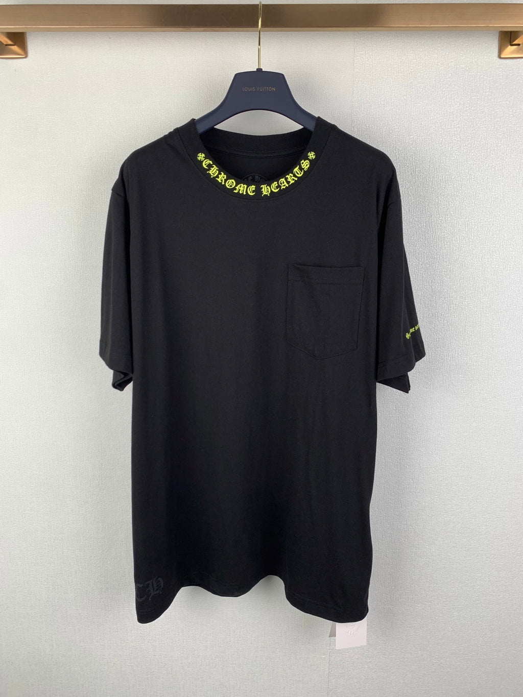Black crew-neck T-shirt with neon green graphic logo on chest and pocket