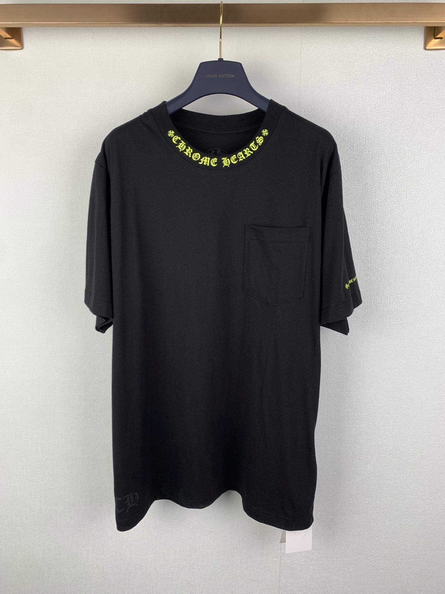 Black crew-neck T-shirt with neon green graphic logo on chest and pocket