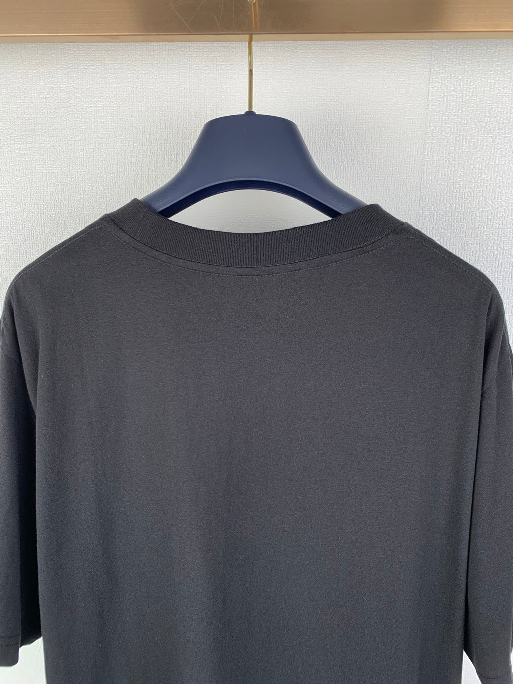 Black crew-neck T-shirt back close-up of collar and upper yoke