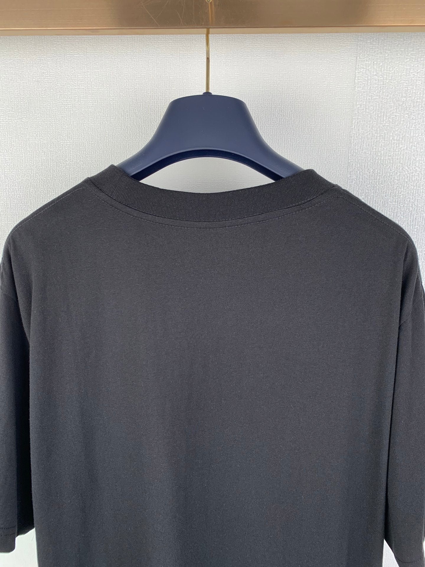 Black crew-neck T-shirt back close-up of collar and upper yoke
