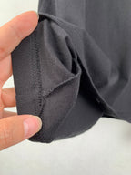 Black T-shirt sleeve cuff and side seam stitching close-up
