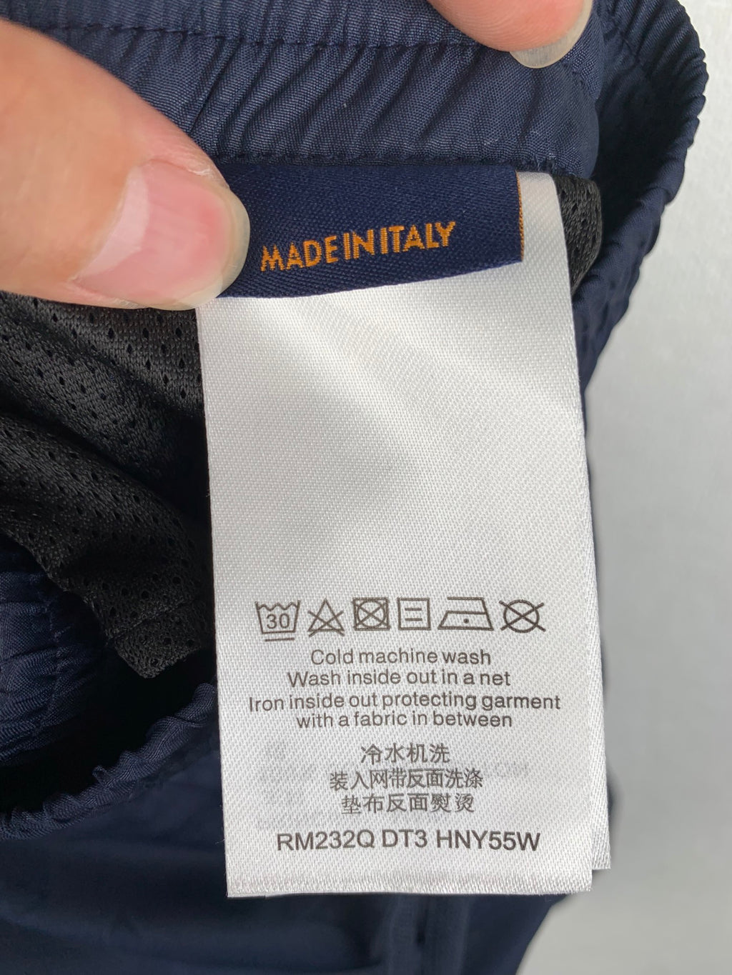 Louis Vuitton pants care label on dark navy fabric