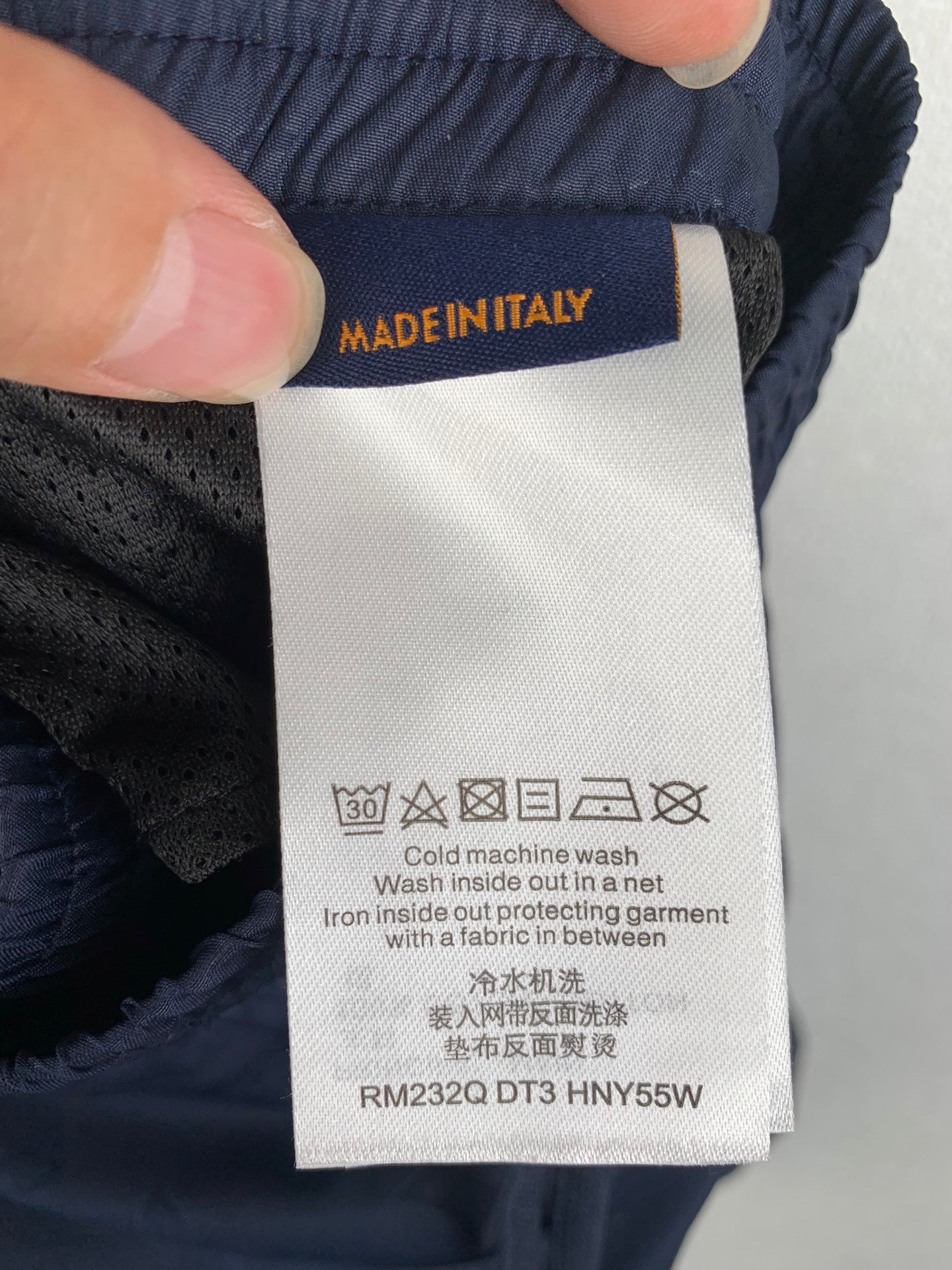 Louis Vuitton pants care label on dark navy fabric