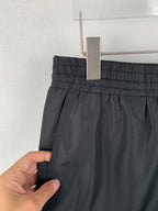 Louis Vuitton black shorts waistband close-up, fabric held by hand