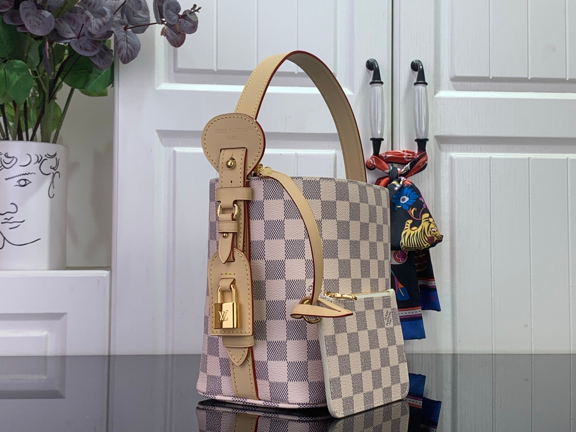 Louis Vuitton Damier checkered bucket-style tote with tan shoulder strap and top handle