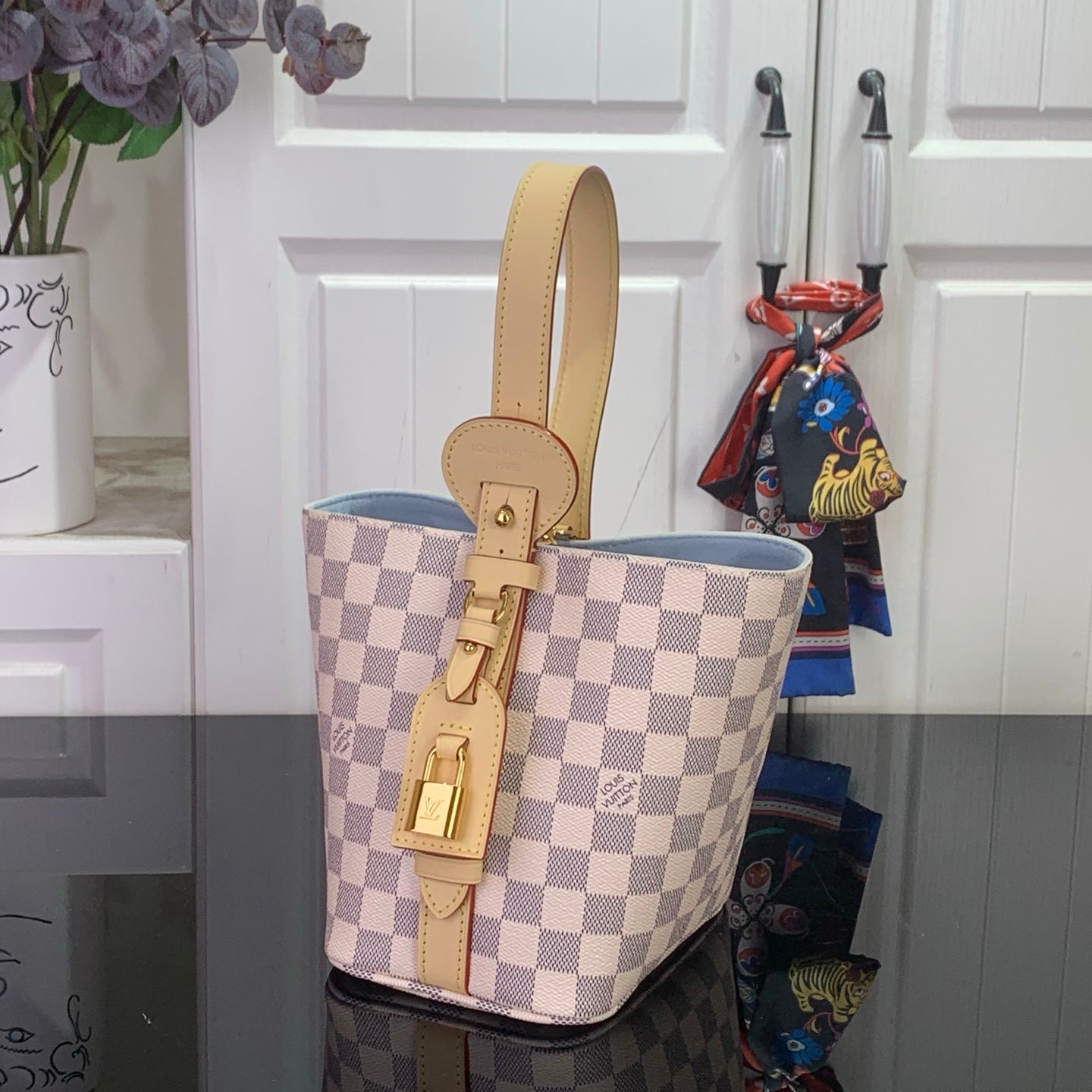 Louis Vuitton Damier checkered bucket tote with tan handles and hanging keychain strap