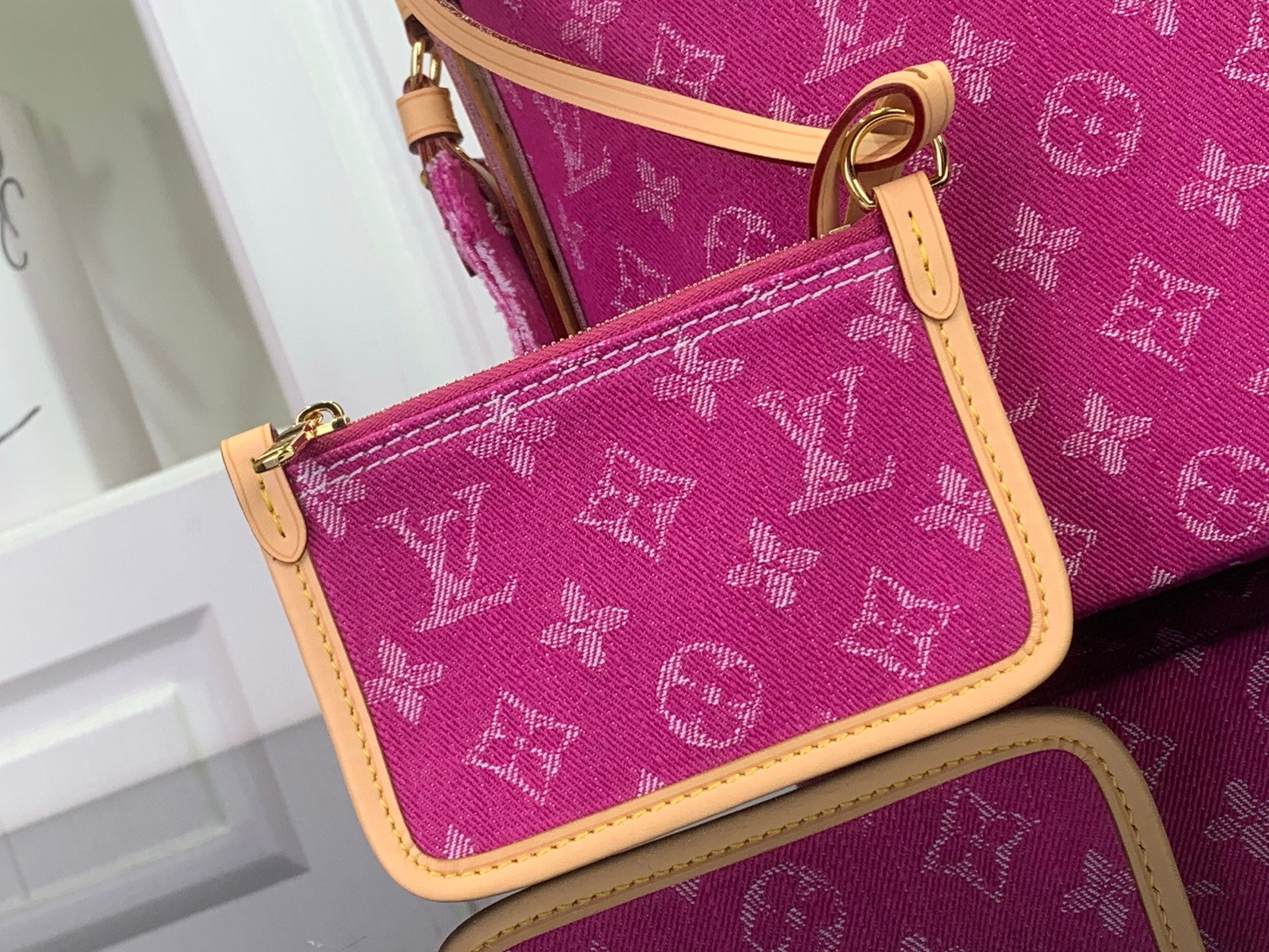 Purple monogram wallet bag with tan trim and gold clasp, close-up