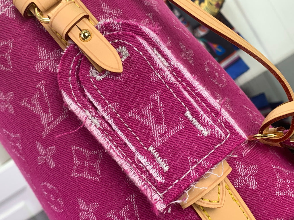 Purple monogram bag corner with tan flap tab and stitched strap