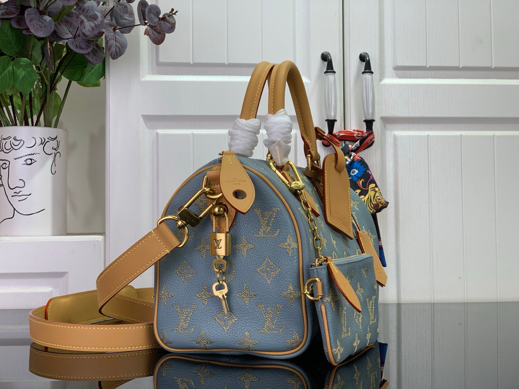 Louis Vuitton monogram bag with side profile, blue canvas and tan leather strap