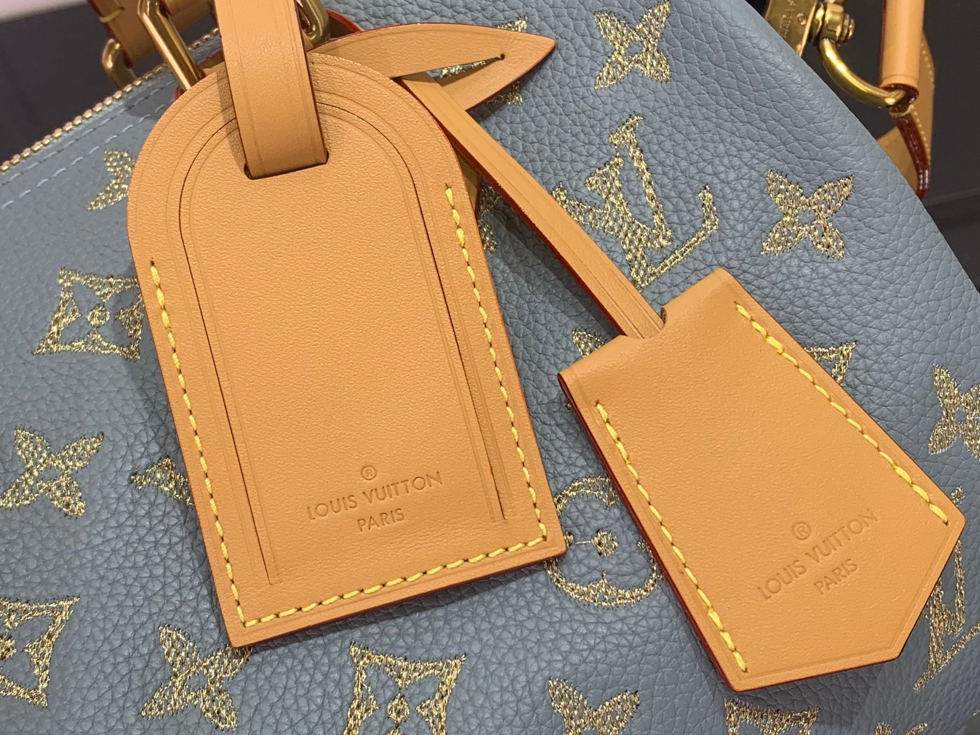 Louis Vuitton monogram bag charm and luggage tag set on blue leather