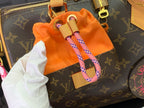 Louis Vuitton monogram bag with orange drawstring pouch and pink webbing strap