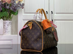 Louis Vuitton monogram handbag with tan leather straps and braided charm detail