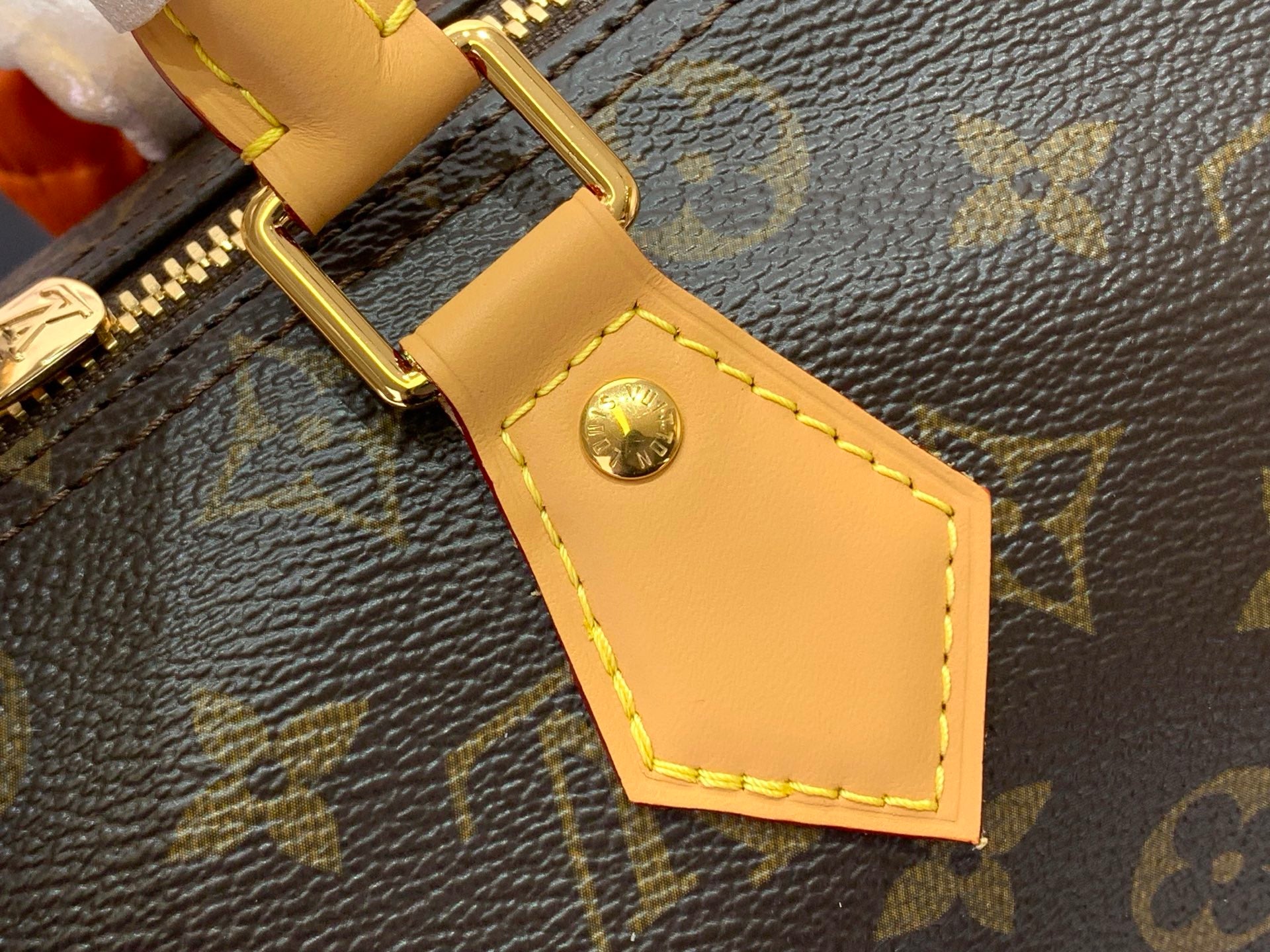 Leather bag strap with gold buckle and stitched tan tab