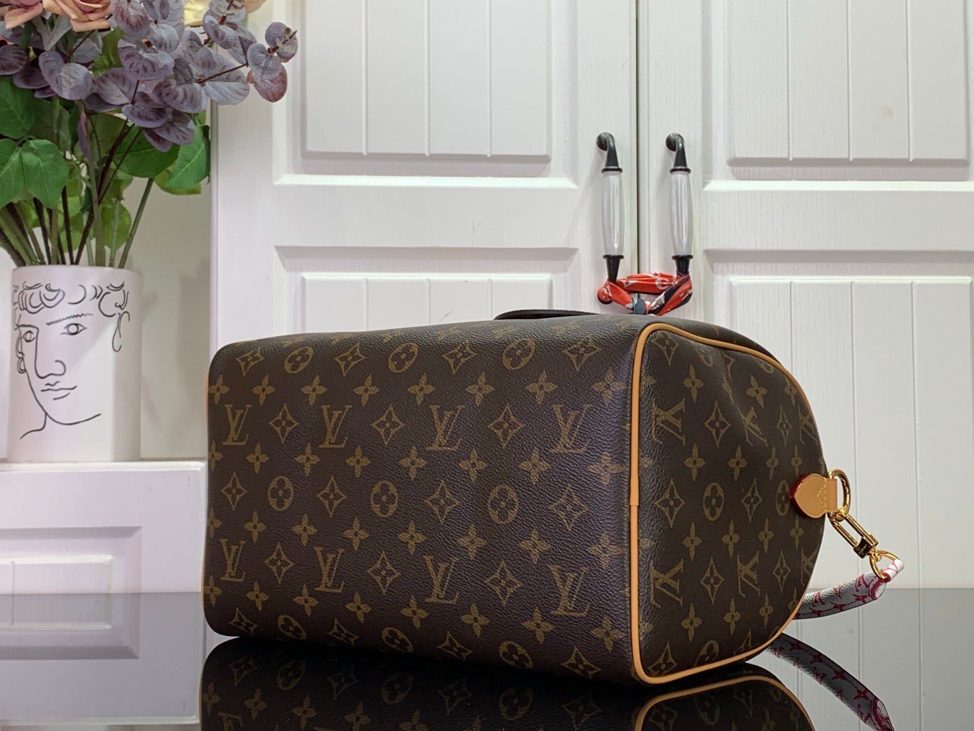 Louis Vuitton monogram shoulder bag with tan leather trim and side pocket